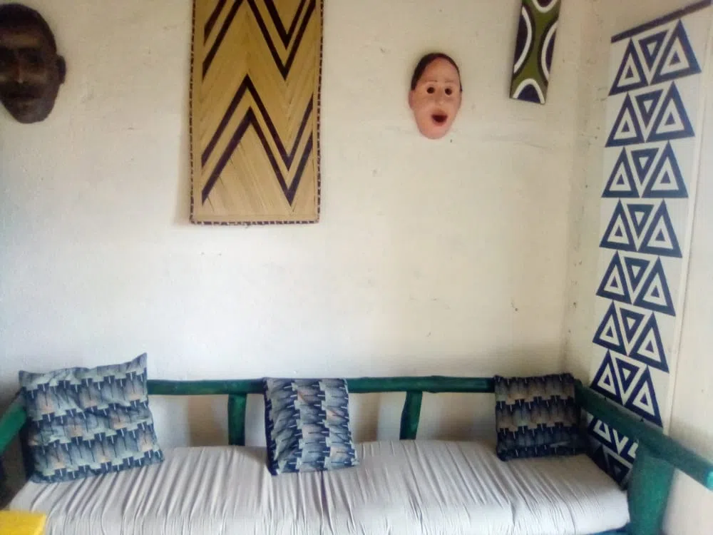 inside of a rwandan home with sofa and traditional decorations